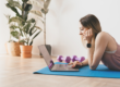 Vrouw op yoga mat achter haar laptop