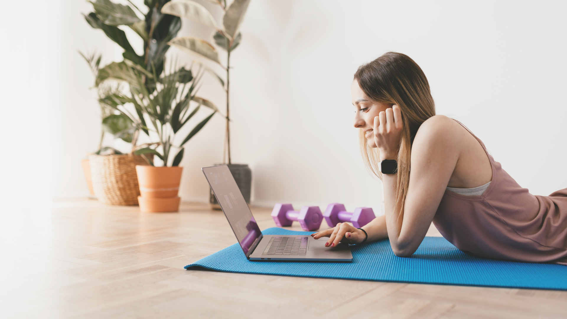 Vrouw op yoga mat achter haar laptop
